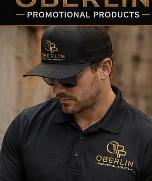 Black Polo, Black Apron, Black Trucker Hat combo with custom embroidered Oberlin logo — Hospitality / Restaurants Uniform Program, Oberlin Promotional Products